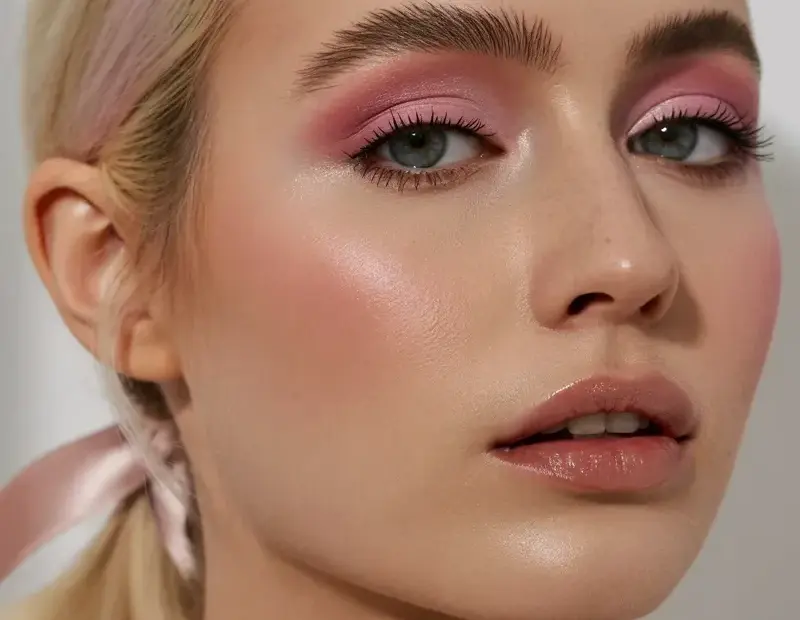 Platinum blonde ponytail with pink ribbon bow – soft romantic makeup look for fair skin